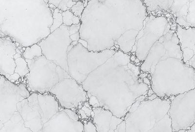 The image features a white marble wall with a pattern of holes and bumps. The wall appears to be textured and has a slightly rough surface. The primary subject of the image is the marble wall, which serves as the main object, scene, or focus of the image. The setting is a room with a white marble wall, and the visual style is a close-up of the wall, showcasing its unique texture and pattern. The colors and mood of the image are predominantly white, giving it a clean