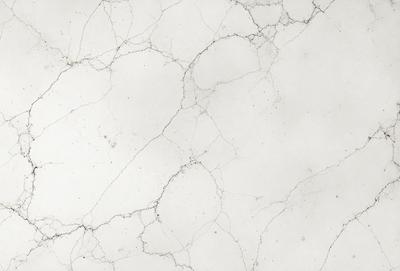 The primary subject of the image is a white marble wall with a rough texture. The setting is a room with a white marble floor. The visual style is a close-up of the marble wall, showcasing its unique texture. The colors and mood of the image are predominantly white, giving it a clean and elegant appearance.