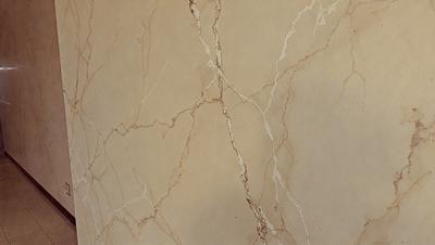 The image features a marble wall with a brown and white color scheme. The wall appears to be textured and has a slightly rough surface. The primary subject of the image is the marble wall, which serves as the main object, scene, or focus of the image. The setting or background of the image is the marble wall, and the visual style is a close-up of the wall, showcasing its texture and color. The colors and mood of the image are warm and earthy, with the brown and white t