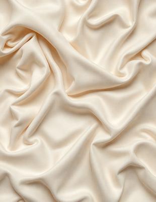 The primary subject of the image is a close-up of a white fabric, possibly a sheet or a piece of clothing. The setting is a white background, which provides a clean and minimalistic appearance. The visual style is a close-up, focusing on the details of the fabric. The colors and mood of the image are predominantly white, giving it a clean and serene atmosphere.