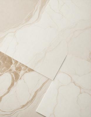 The primary subject of the image is a piece of marble paper, which is placed on a marble countertop. The setting is a kitchen, with the marble paper and countertop being the main focus of the scene. The visual style is a photo, capturing the natural texture and color of the marble paper and countertop. The colors and mood of the image are predominantly neutral, with the marble paper and countertop being the main elements in the scene.