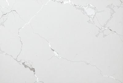 The primary subject of the image is a white marble wall with a pattern of holes and cracks. The setting is a room with a white marble floor. The visual style is a close-up of the marble wall, showcasing its unique texture and pattern. The colors and mood of the image are predominantly white, giving it a clean and elegant appearance.