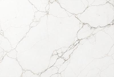 The primary subject of the image is a white marble wall with a pattern of holes and grooves. The setting is a room with a white marble floor. The visual style is a close-up of the marble wall, showcasing its unique texture and pattern. The colors and mood of the image are predominantly white, giving it a clean and elegant appearance.
