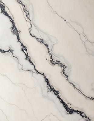 The image features a marble surface with a pattern of swirls and lines. The marble appears to be white and gray, creating a visually appealing and elegant design. The pattern of the marble surface adds depth and texture to the overall composition.