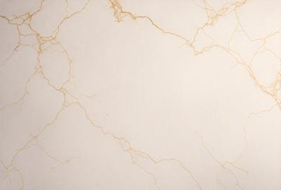 The primary subject of the image is a white marble wall with a pattern of yellow streaks. The setting is a room with a white marble floor. The visual style is a close-up of the marble wall, showcasing its unique texture and pattern. The colors and mood of the image are predominantly white and neutral, with the yellow streaks adding a touch of warmth and interest to the marble surface.