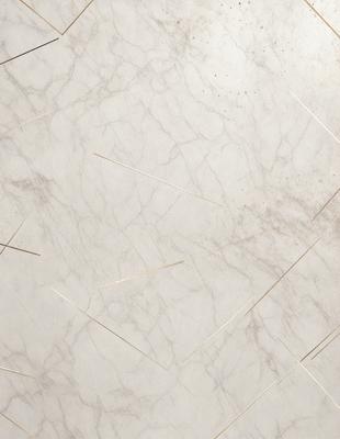 The primary subject of the image is a marble countertop with a pattern of gold lines. The setting is a kitchen, and the visual style is a close-up of the marble countertop. The colors and mood of the image are predominantly white and gold, giving it a luxurious and elegant appearance.