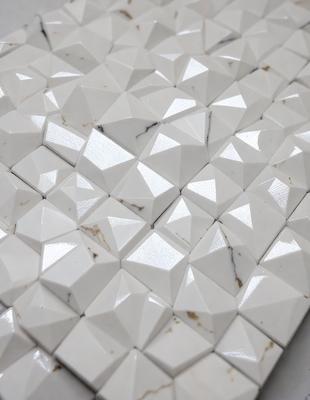 The primary subject of the image is a white tile with a geometric pattern on it. The setting is a white table, and the visual style is a close-up of the tile. The colors and mood of the image are predominantly white, giving it a clean and minimalist appearance.