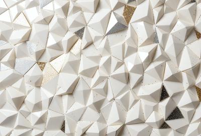 The primary subject of the image is a white wall with a pattern of white triangles. The setting is a room with a white background. The visual style is a close-up of the wall, showcasing the intricate pattern of the triangles. The colors and mood of the image are predominantly white, giving it a clean and minimalist appearance.