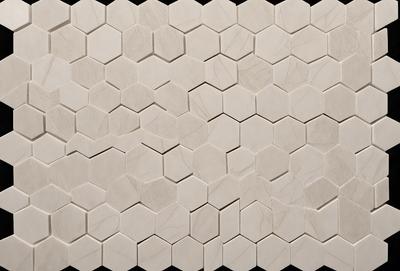 The primary subject of the image is a white tile wall with a hexagonal pattern. The setting is a room with a white tile floor. The visual style is a close-up of the tile wall, showcasing the intricate pattern. The dominant colors are white and gray, creating a clean and minimalist atmosphere.