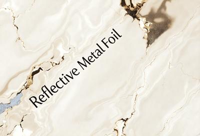 The primary subject of the image is a piece of reflective foil. The setting is a marble surface, which serves as the background. The visual style is a close-up of the reflective foil, showcasing its reflective properties. The colors in the image are predominantly white, giving the scene a clean and elegant appearance.