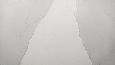 The primary subject of the image is a white wall with a pattern of cracks and crevices. The setting is a room with a white surface, and the visual style appears to be a photo. The dominant colors are white and grey, creating a clean and minimalist atmosphere.
