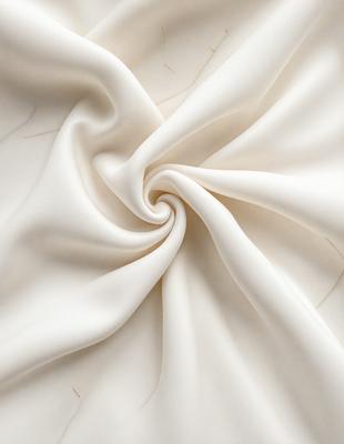 The primary subject of the image is a white sheet of fabric, which is the main object, scene, or focus of the image. The setting is a white background, which provides a clean and minimalistic environment. The visual style is a close-up of the fabric, showcasing its texture and details. The colors and mood of the image are predominantly white, giving it a clean and serene atmosphere.