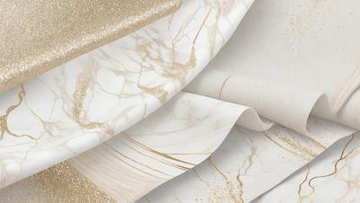 The primary subject of the image is a roll of marble paper, which is a decorative paper with a marble-like texture. The paper is displayed in a variety of colors, including gold, white, and black. The setting is a table, and the visual style is a close-up of the paper roll. The colors and mood of the image are elegant and sophisticated, with the gold and white colors adding a touch of luxury to the overall atmosphere.