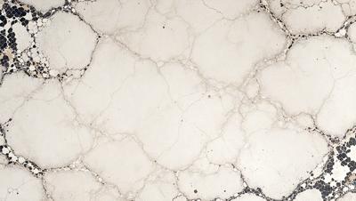 The image features a white marble surface with a pattern of holes and cracks. The setting appears to be a bathroom, as the marble is a common choice for bathroom countertops. The visual style is a close-up of the marble surface, showcasing its unique texture and pattern. The dominant colors in the image are white and gray, creating a clean and elegant atmosphere.