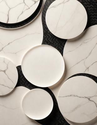 The primary subject of the image is a collection of white plates arranged on a black and white marble surface. The setting is a patterned marble wall, which serves as the background for the plates. The visual style is a combination of photo and digital art, creating a unique and eye-catching display. The colors and mood of the image are predominantly black and white, giving it a classic and elegant appearance.
