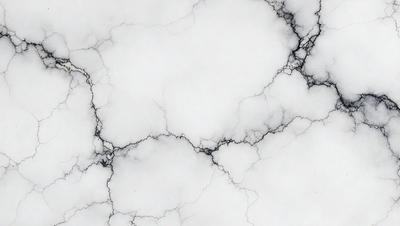 The image features a white marble surface with a pattern of black and white veins. The marble appears to be cracked, giving it a unique and textured appearance. The overall mood of the image is elegant and sophisticated, with the marble surface serving as a striking backdrop.