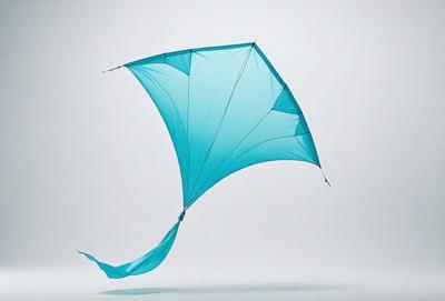The primary subject of the image is a blue kite with a long tail, flying in the air. The kite is the main focus of the image, and it appears to be a photo of the kite in action. The setting is a white background, which provides a clean and uncluttered environment for the kite to be the main subject. The visual style is a photo of the kite, and the colors and mood are predominantly blue, creating a sense of calm and freedom.