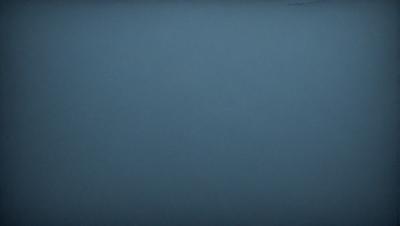 The primary subject of the image is a large, empty, and dark blue sky. The setting is a vast, open space with no visible landmarks or objects. The visual style is a natural, outdoor scene with a sense of vastness and tranquility. The colors and mood are predominantly dark blue, creating a calm and serene atmosphere.