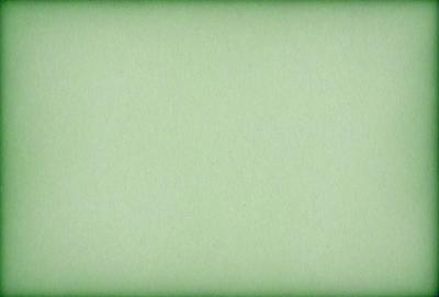 The primary subject of the image is a large, green sheet of paper. The setting is a plain, white background, and the visual style is a close-up of the paper. The colors are predominantly green, and the mood is calm and uncluttered.