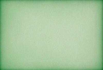 The primary subject of the image is a large, green sheet of paper. The setting is a plain, white background, and the visual style is a close-up of the paper. The colors and mood of the image are predominantly green, giving it a calm and serene atmosphere.