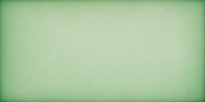 The primary subject of the image is a large, green piece of paper. The setting is a white background, which provides a clean and uncluttered appearance. The visual style is a close-up of the paper, showcasing its texture and color. The colors and mood of the image are predominantly green, giving it a calm and serene atmosphere.
