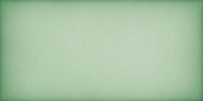 The primary subject of the image is a large, green sheet of paper. The setting is a plain, white background, and the visual style is a close-up of the paper. The colors are predominantly green, and the mood is calm and uncluttered.