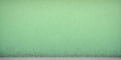 The primary subject of the image is a green wall with a pattern of dots. The setting is a room with a green wall, and the visual style is a photo. The dominant colors are green and white, creating a calm and soothing atmosphere.