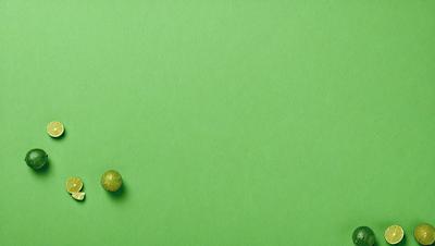 The primary subject of the image is a small yellow object, which appears to be a piece of fruit, such as a banana or an apple. The setting is a green background, which creates a contrasting and vibrant atmosphere. The visual style of the image is a close-up of the yellow object, emphasizing its details and texture. The colors and mood of the image are lively and energetic, with the bright green background and the yellow fruit creating a sense of freshness and vitality.