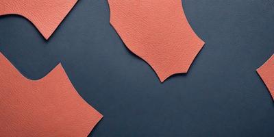 The primary subject of the image is a piece of leather, which is the main object in the scene. The leather is displayed on a blue surface, creating a contrast between the two colors. The visual style of the image is a close-up of the leather, showcasing its texture and details. The colors in the image are predominantly blue and orange, with the blue surface providing a calm and soothing atmosphere.