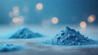 The primary subject of the image is a blue substance, possibly a powder or a liquid, with a blue color and a slightly metallic appearance. The setting is a white surface, which provides a clean and contrasting background for the blue substance. The visual style of the image is a close-up, focusing on the details of the blue substance. The colors and mood of the image are predominantly blue, creating a calm and serene atmosphere.