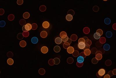 The primary subject of the image is a collection of bright, colorful lights, which are the main objects in the scene. The lights are scattered throughout the image, creating a visually striking and vibrant atmosphere. The setting appears to be a dark background, which further emphasizes the brightness of the lights. The visual style of the image is a combination of photo and digital art, as the lights are captured in a way that resembles a painting or a digital artwork. The colors and mood of the image are predomin