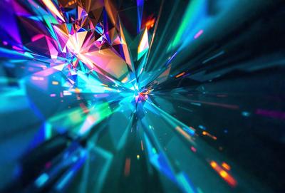 The primary subject of the image is a close-up of a colorful, geometric pattern, possibly a crystal or a piece of art. The setting is a dark background, which contrasts with the vibrant colors of the pattern. The visual style appears to be a combination of a photo and digital art, as the colors and patterns are intricate and detailed. The overall atmosphere is lively and captivating, with the bright colors and unique design of the pattern.