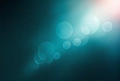 The primary subject of the image is a blue background with a pattern of bubbles or circles. The setting appears to be a dark room, and the visual style is a combination of a photo and digital art. The dominant colors are blue and white, creating a calm and serene atmosphere.