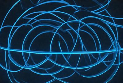 The primary subject of the image is a blue, glowing, and curved wire. The setting is a dark background, which emphasizes the blue wire's vibrant color. The visual style is a close-up of the wire, showcasing its unique texture and pattern. The colors and mood of the image are predominantly blue, creating a serene and calming atmosphere.