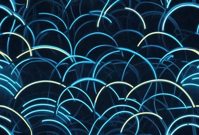 The primary subject of the image is a blue light pattern, which appears to be a digital art or illustration. The setting is a dark background, and the visual style is a combination of light and dark elements. The dominant colors are blue and yellow, creating a vibrant and lively atmosphere.