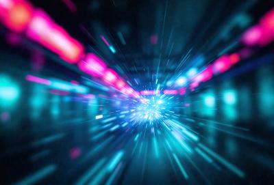 The primary subject of the image is a brightly colored, blurry tunnel. The setting is a dark room with a blue background. The visual style is a combination of a photo and digital art, creating a unique and vibrant atmosphere. The dominant colors are blue and pink, with the pink hue adding a sense of warmth and energy to the scene.