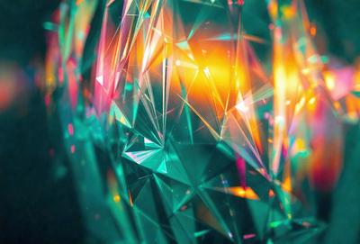 The primary subject of the image is a close-up of a colorful, crystal-like structure, possibly a piece of art or a decorative item. The setting is a dark background, which contrasts with the vibrant colors of the crystal. The visual style appears to be a combination of digital art and illustration, creating a unique and eye-catching design. The colors and mood of the image are lively and energetic, with the bright colors of the crystal drawing attention and creating a sense of