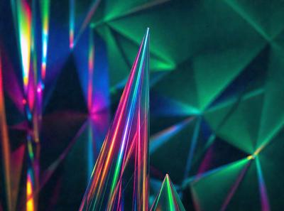 The primary subject of the image is a colorful, three-dimensional structure made of colored glass or plastic. The structure is shaped like a tall, thin triangle and is surrounded by a vibrant, colorful background. The visual style of the image is a combination of photo and digital art, creating a unique and eye-catching display. The colors and mood of the image are lively and energetic, with the bright colors of the structure and the background creating a sense of excitement and energy.