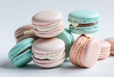The image features a stack of six macaroon cookies, each with a different color. The cookies are arranged in a visually appealing manner, with some stacked on top of each other and others placed next to each other. The colors of the cookies are predominantly white, pink, and blue, creating a vibrant and appetizing display. The overall atmosphere of the image is cheerful and inviting, showcasing the delicious treats.
