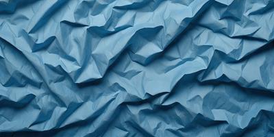 The primary subject of the image is a blue paper with a wrinkled texture. The setting is a blue background, and the visual style appears to be a photo. The dominant colors are blue and white, creating a calm and serene atmosphere.
