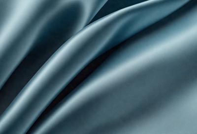 The primary subject of the image is a blue fabric, which is the main object, scene, or focus of the image. The setting or background is a dark blue surface, and the visual style is a photo. The colors and mood of the image are predominantly dark blue, creating a calm and serene atmosphere.