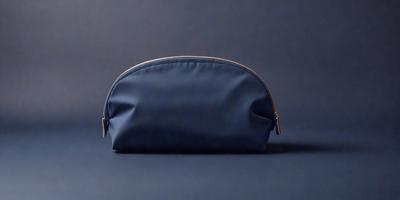 The primary subject of the image is a blue cosmetic bag. The setting is a blue background, which creates a contrast with the bag. The visual style is a photo, and the colors and mood are predominantly blue, giving the image a calm and serene atmosphere.