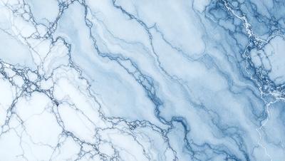 The primary subject of the image is a blue and white marble-like surface, which appears to be a wall or a countertop. The setting is a room with a blue and white color scheme. The visual style is a close-up of the marble surface, showcasing its intricate patterns and textures. The colors and mood of the image are predominantly blue and white, creating a calm and elegant atmosphere.