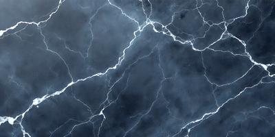 The primary subject of the image is a close-up of a marble surface with a blue and white color scheme. The setting is a dark room, and the visual style appears to be a photo. The dominant colors are blue and white, creating a calm and serene atmosphere.