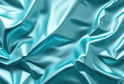 The primary subject of the image is a close-up of a shiny, metallic surface, possibly a piece of fabric or a metal sheet. The setting is a dark background, which contrasts with the shiny surface. The visual style appears to be a photo or a close-up of a metal sheet, with a focus on the texture and reflective quality of the surface. The colors in the image are predominantly dark, with the shiny surface being the main focus and source of light. The overall atmosphere of the image