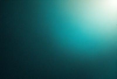 The primary subject of the image is a blue background with a green hue. The setting is a dark, blue-green room, and the visual style is a close-up of the blue and green background. The colors and mood of the image are predominantly dark and moody, with a hint of a bright green hue.