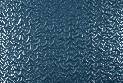 The primary subject of the image is a blue surface with a pattern of black and white shapes. The setting appears to be a room with a blue wall, and the visual style is a close-up of the blue surface. The dominant colors are blue and black, creating a calm and soothing atmosphere.