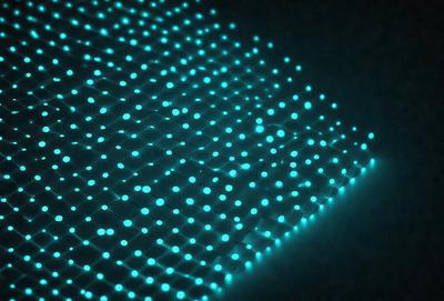 The primary subject of the image is a blue, glowing, and patterned surface. The setting appears to be a dark room, with the blue light creating a unique atmosphere. The visual style of the image is a combination of digital art and illustration, as the blue light creates a distinctive and eye-catching effect. The colors and mood of the image are predominantly blue, with a slightly mysterious and futuristic vibe.