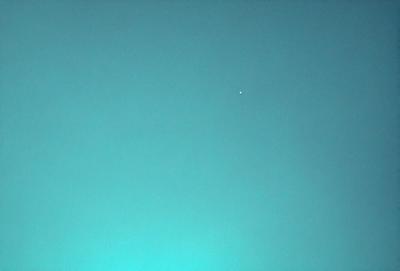 The primary subject of the image is a bright star in the sky. The setting is a clear blue sky, which serves as the perfect backdrop for the star. The visual style of the image is a photo, capturing the beauty of the star in its natural environment. The colors and mood of the image are predominantly blue, creating a serene and peaceful atmosphere.