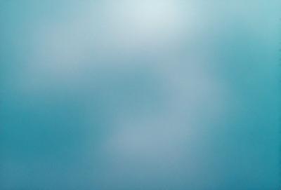 The primary subject of the image is a cloudy blue sky. The setting is a vast, open space with no visible landmarks or objects. The visual style is a natural, outdoor scene. The colors and mood are predominantly blue, creating a calm and serene atmosphere.